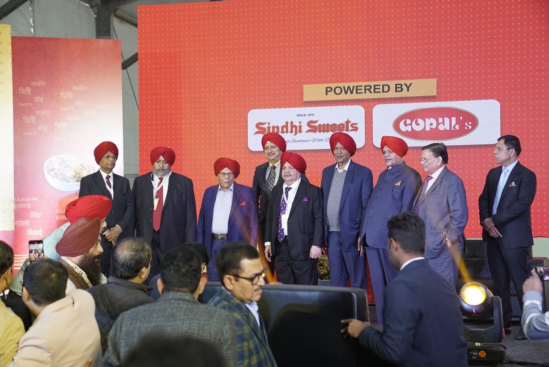 Dignitaries gather on stage in front of the WMNC backdrop