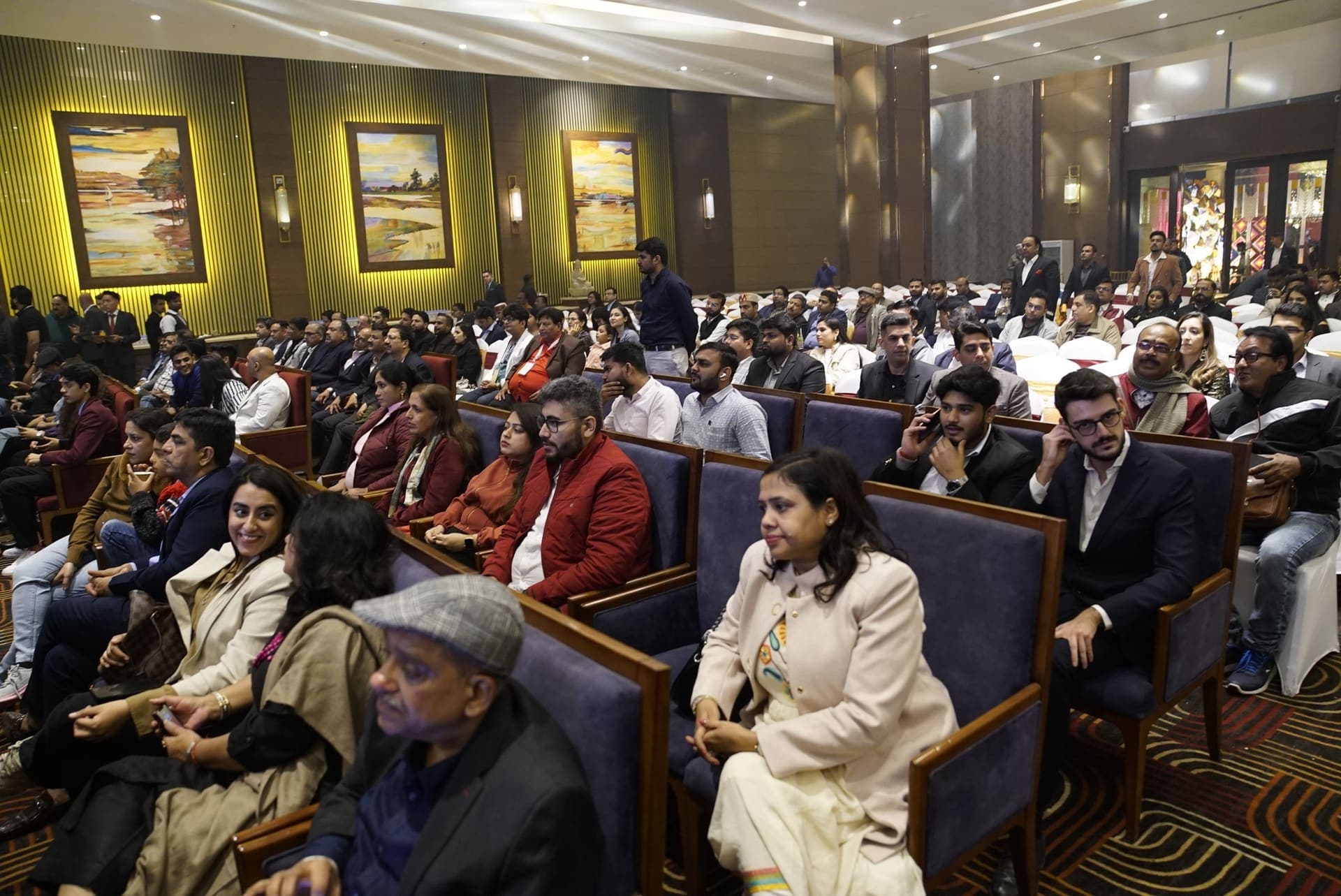 A packed hall listens to a panel discussion