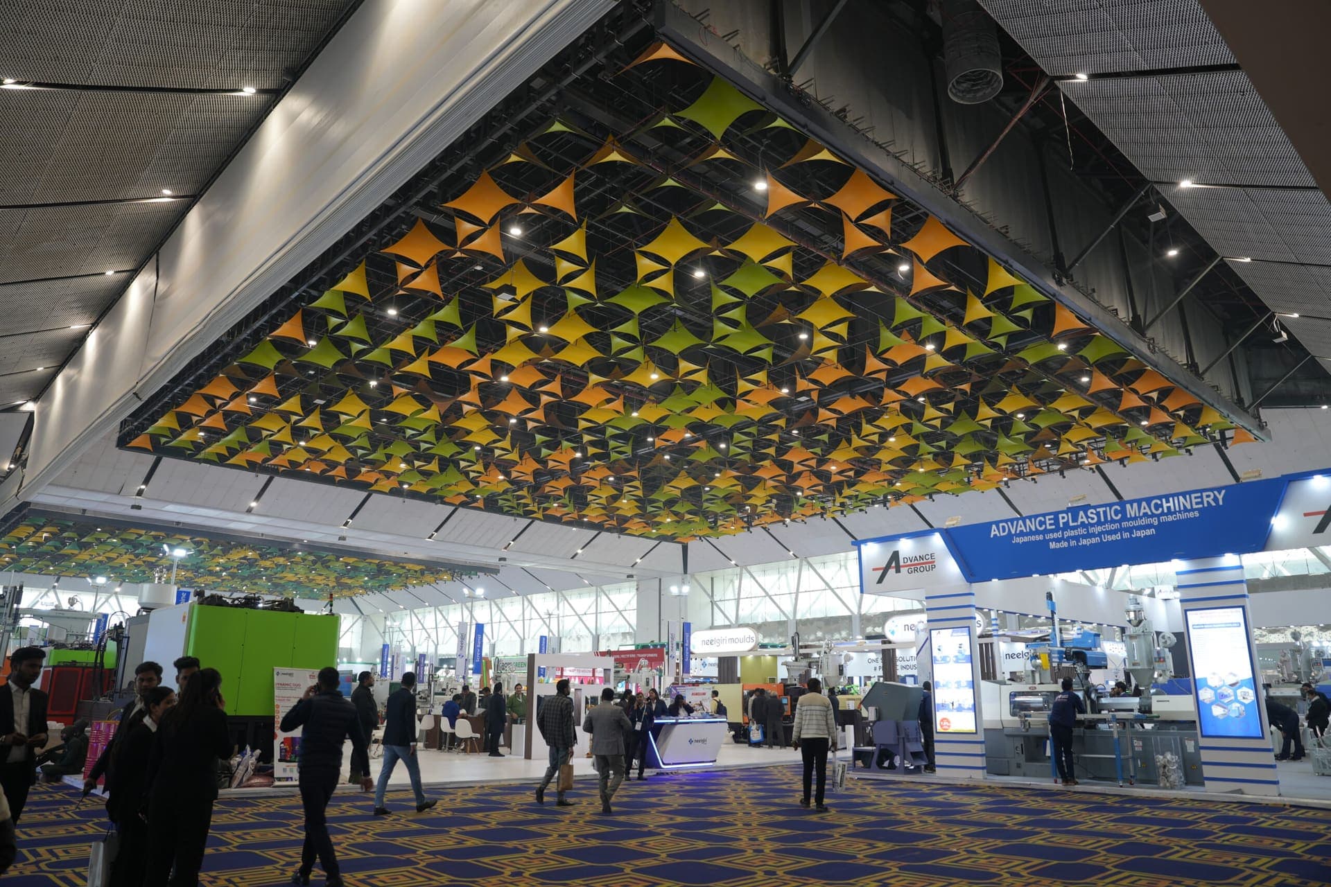 The exhibition hall at YASHOBHOOMI with its patterned ceiling and exhibitor stands below